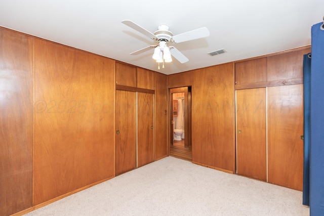 unfurnished bedroom featuring carpet floors, ceiling fan, and visible vents
