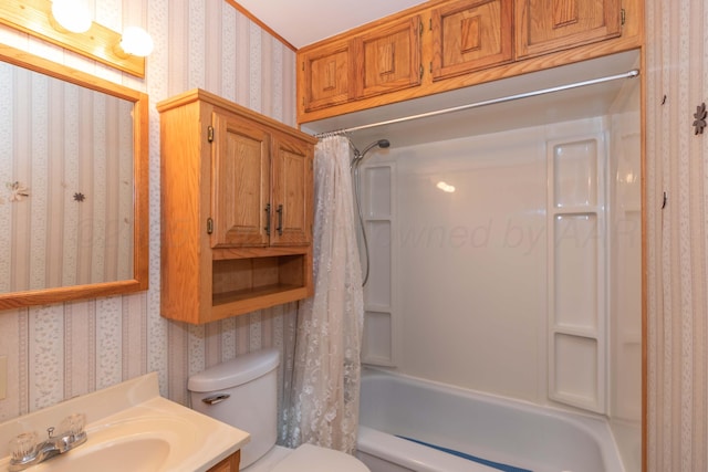 bathroom with vanity, toilet, wallpapered walls, and shower / tub combo