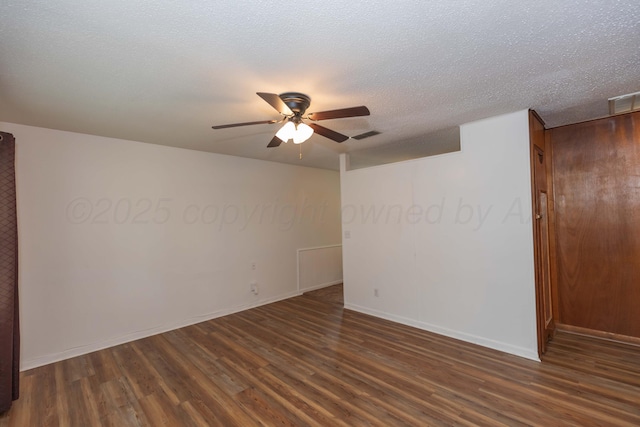 spare room featuring visible vents, baseboards, a textured ceiling, a ceiling fan, and dark wood finished floors