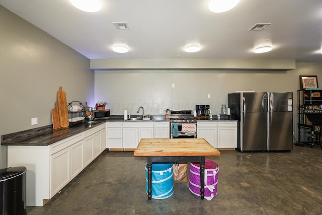 18150 19th St, Amarillo, TX 79124 - kitchen featuring appliances with stainless steel finishes, concrete floors, a sink, white cabinetry, and wood counters