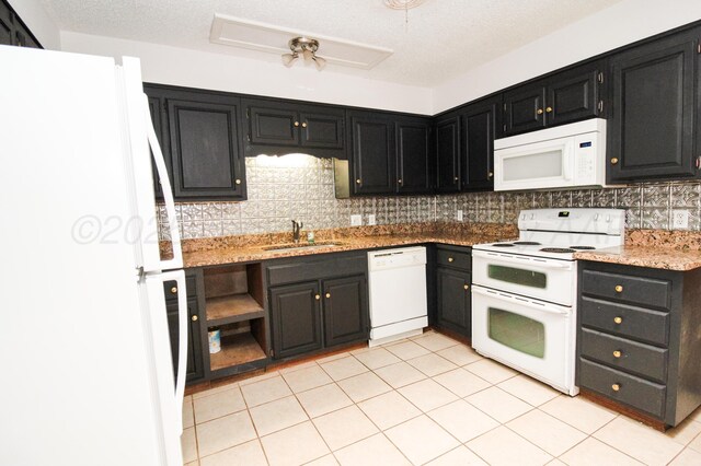 6108 Belpree Rd, Amarillo, TX 79106 - kitchen with white appliances, dark cabinets, backsplash, light stone countertops, and light tile patterned floors