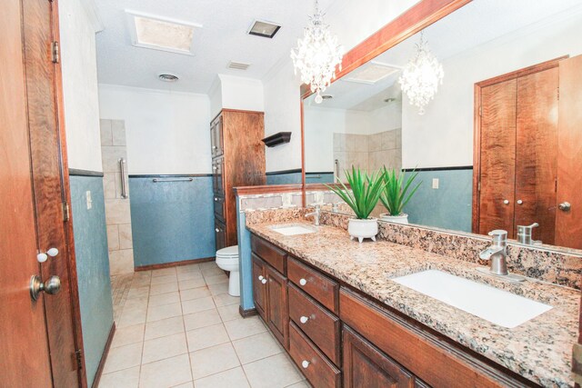 6108 Belpree Rd, Amarillo, TX 79106 - full bath with double vanity, tile patterned floors, ornamental molding, a wainscoted wall, and a chandelier