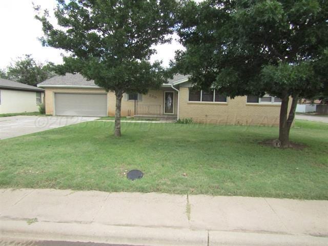 view of front of property featuring a garage and a front lawn