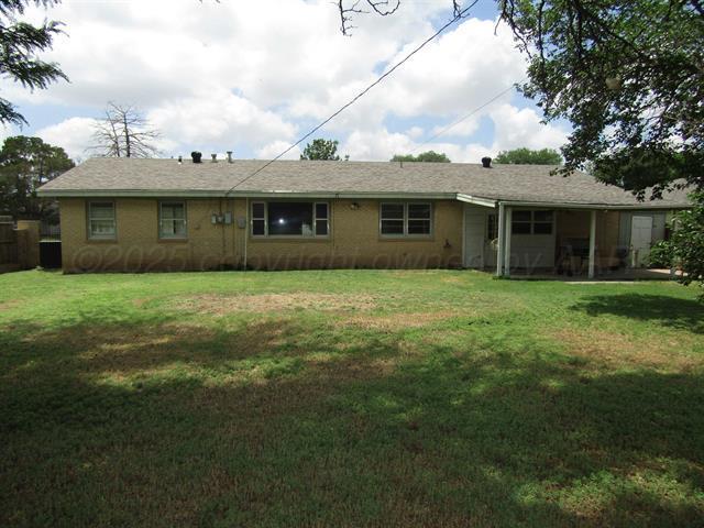 back of property featuring a lawn