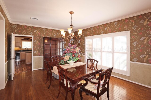 18 Didrickson Ln, Amarillo, TX 79124 - dining area with a chandelier, dark wood-style flooring, wallpapered walls, crown molding, and a wainscoted wall