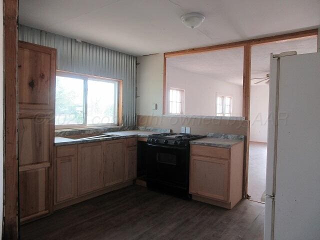 413 N Bowie Ave, Tulia, TX 79088 - kitchen featuring gas stove, freestanding refrigerator, dark wood-type flooring, and ceiling fan