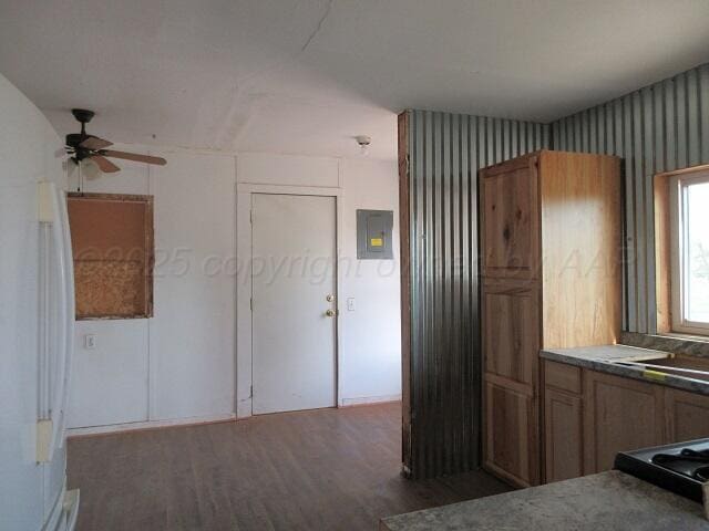413 N Bowie Ave, Tulia, TX 79088 - kitchen with wood finished floors, a ceiling fan, electric panel, wallpapered walls, and freestanding refrigerator