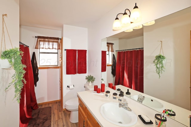 full bath featuring wood finished floors, vanity, and toilet