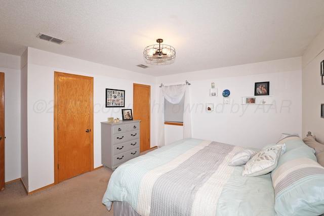 bedroom with light colored carpet and a chandelier