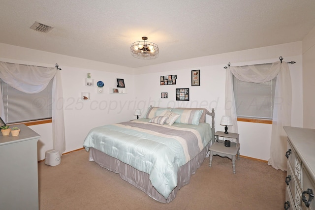 bedroom with light colored carpet, baseboards, a chandelier, and a textured ceiling