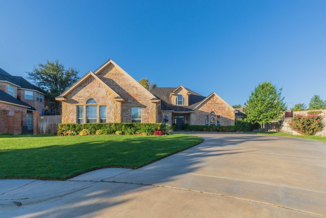 view of front of property with fence, a residential view, a front lawn, and brick siding