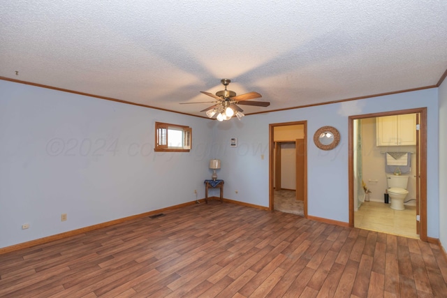 spare room with hardwood / wood-style floors, ceiling fan, crown molding, and a textured ceiling