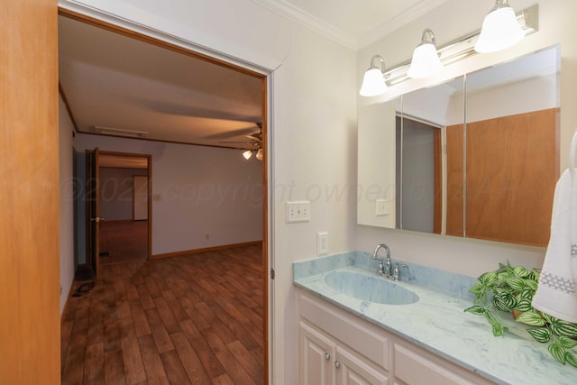 bathroom with hardwood / wood-style floors, vanity, ceiling fan, and ornamental molding