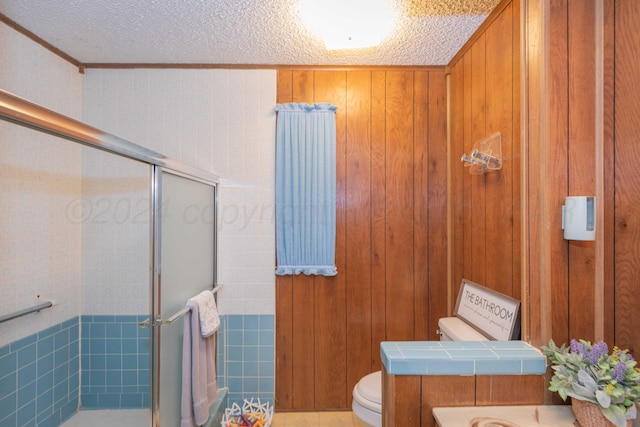 bathroom with a shower with door, a textured ceiling, and toilet