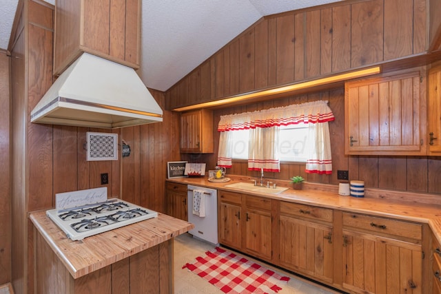 kitchen with lofted ceiling, white appliances, sink, and custom range hood