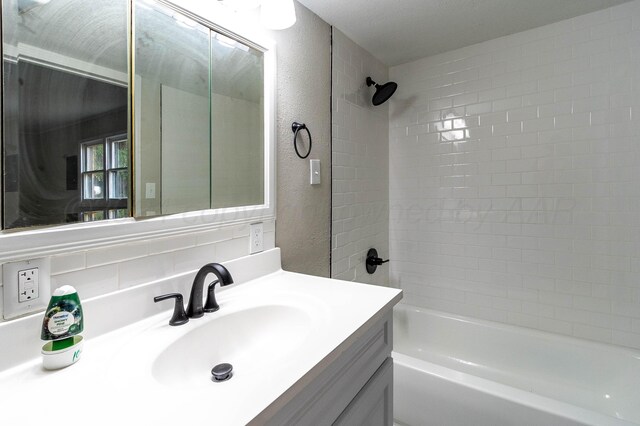 bathroom featuring tiled shower / bath combo and vanity