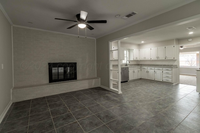 unfurnished living room with a brick fireplace, ceiling fan, crown molding, and sink