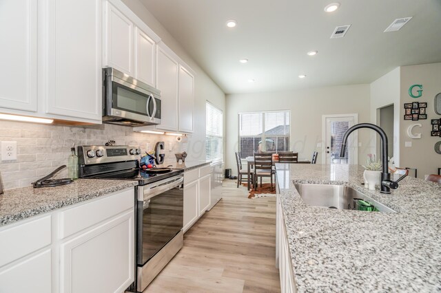 1706 Morningside Ave, Amarillo, TX 79118 - kitchen with appliances with stainless steel finishes, white cabinets, recessed lighting, decorative backsplash, and light stone counters