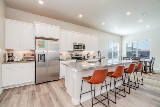 1706 Morningside Ave, Amarillo, TX 79118 - kitchen featuring stainless steel appliances, light wood-type flooring, decorative backsplash, an island with sink, and recessed lighting