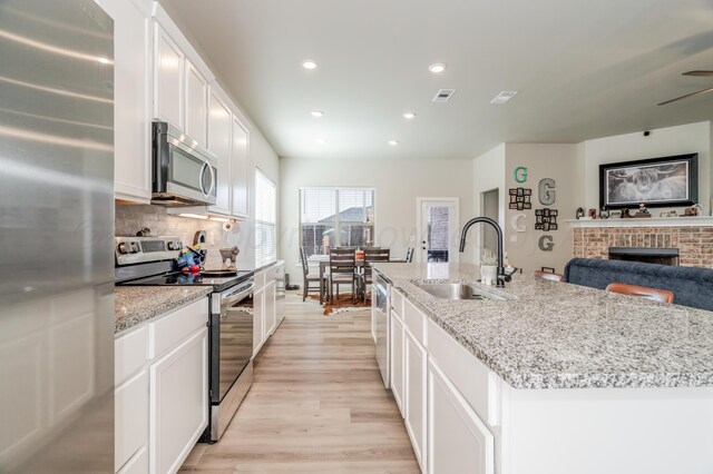 1706 Morningside Ave, Amarillo, TX 79118 - kitchen featuring stainless steel appliances, recessed lighting, light wood-type flooring, white cabinets, and decorative backsplash