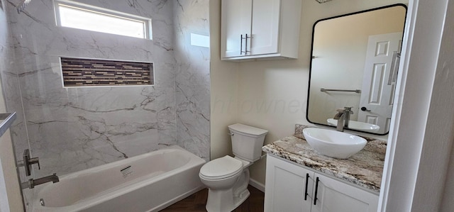 full bathroom with tiled shower / bath, vanity, and toilet