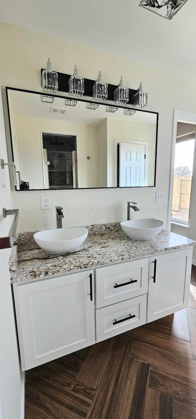 bathroom featuring parquet flooring and vanity