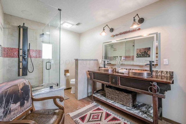 1513 S Girl Scout Rd, Amarillo, TX 79124 - full bathroom with wood finished floors, a shower stall, toilet, and double vanity