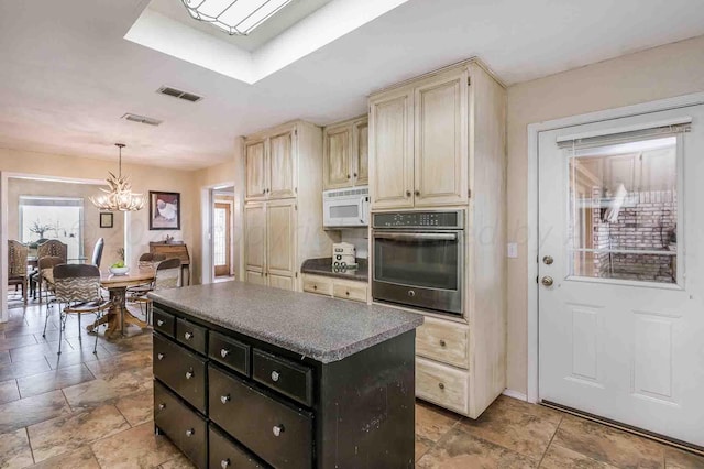 1513 S Girl Scout Rd, Amarillo, TX 79124 - kitchen with oven, white microwave, a chandelier, cream cabinetry, and a kitchen island