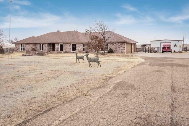 1513 S Girl Scout Rd, Amarillo, TX 79124 - view of front of house featuring driveway, an attached garage, brick siding, and an outdoor structure