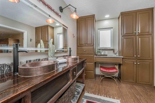 1513 S Girl Scout Rd, Amarillo, TX 79124 - bathroom with wood finished floors, double vanity, and a textured ceiling