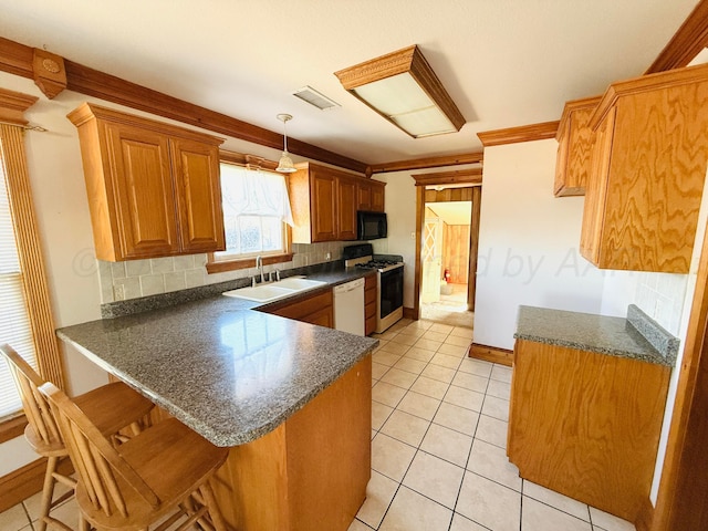 kitchen with a sink, range with gas stovetop, dark countertops, a peninsula, and dishwasher