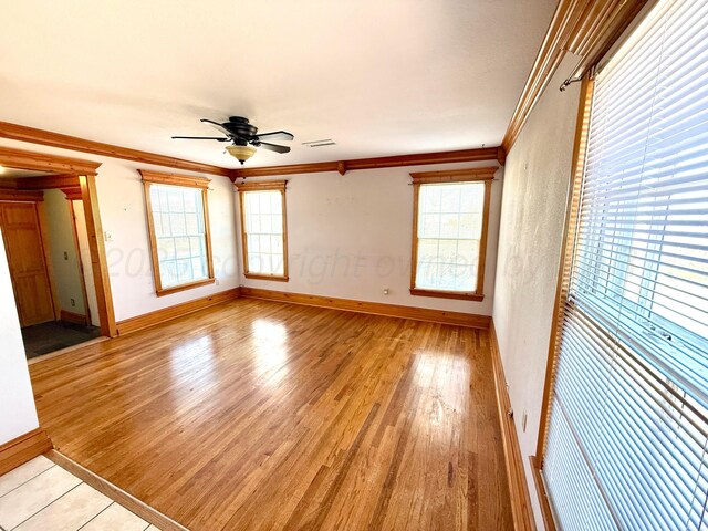 unfurnished room featuring visible vents, light wood-type flooring, crown molding, and ceiling fan