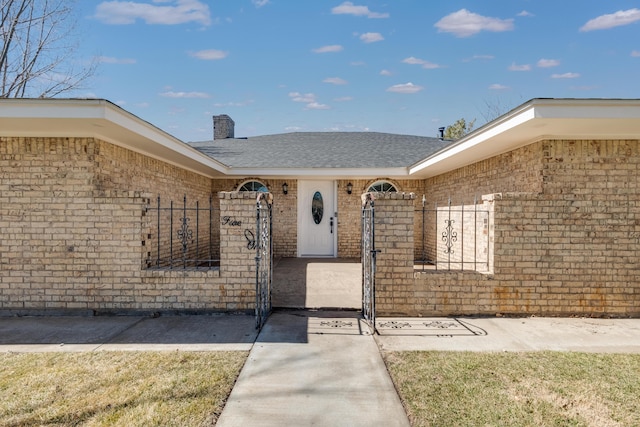 doorway to property with brick siding and a chimney