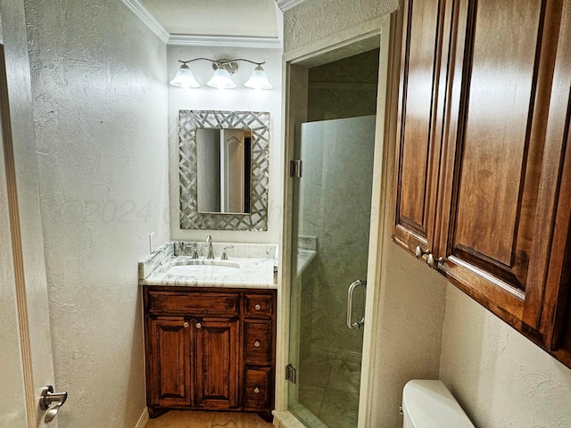 bathroom featuring a shower with door, vanity, toilet, and ornamental molding