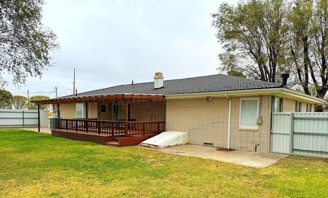 back of property featuring central air condition unit, a wooden deck, a lawn, and a patio