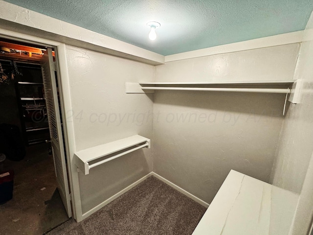 walk in closet featuring dark colored carpet