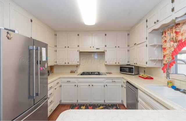 6102 Calumet Rd, Amarillo, TX 79106 - kitchen featuring stainless steel appliances, white cabinets, and decorative backsplash