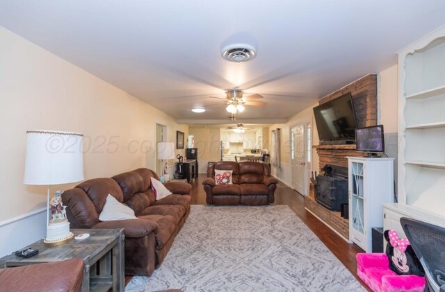 6102 Calumet Rd, Amarillo, TX 79106 - living room featuring dark wood-type flooring, ceiling fan, and a fireplace