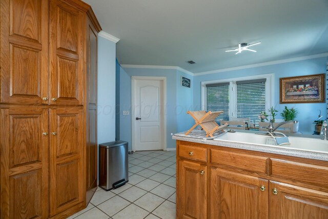 8301 San Antonio Dr, Amarillo, TX 79118 - kitchen with a sink, brown cabinetry, ornamental molding, light countertops, and light tile patterned floors