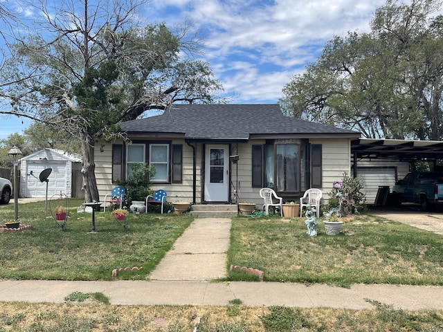 view of front facade with a garage, a front yard, and an outbuilding