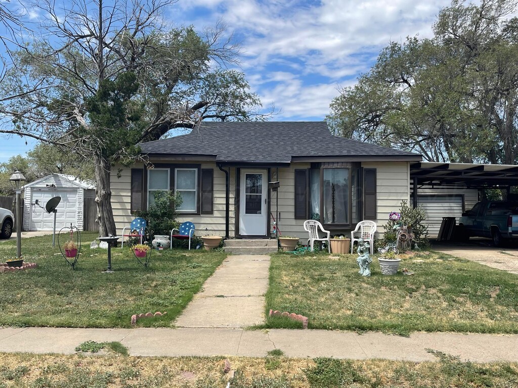 4006 S Hughes St, Amarillo, TX 79110 - bungalow-style house with a front lawn, a shingled roof, an attached carport, a garage, and driveway