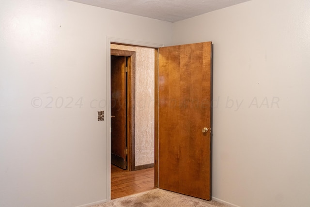 unfurnished room with a textured ceiling and light hardwood / wood-style flooring