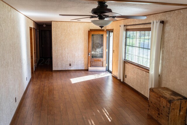 unfurnished room with dark wood-type flooring, a textured ceiling, and ceiling fan