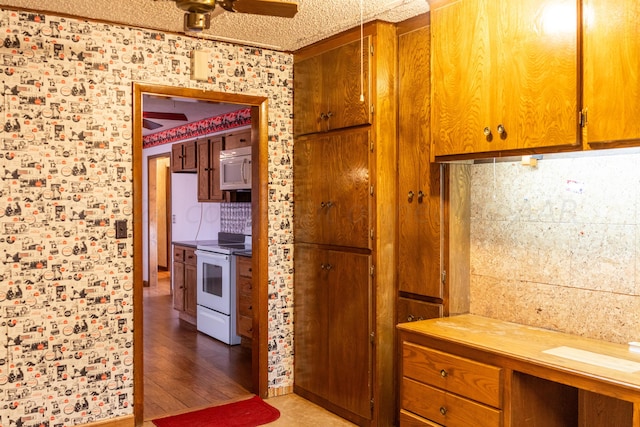 kitchen with white appliances, ceiling fan, a textured ceiling, and light hardwood / wood-style flooring