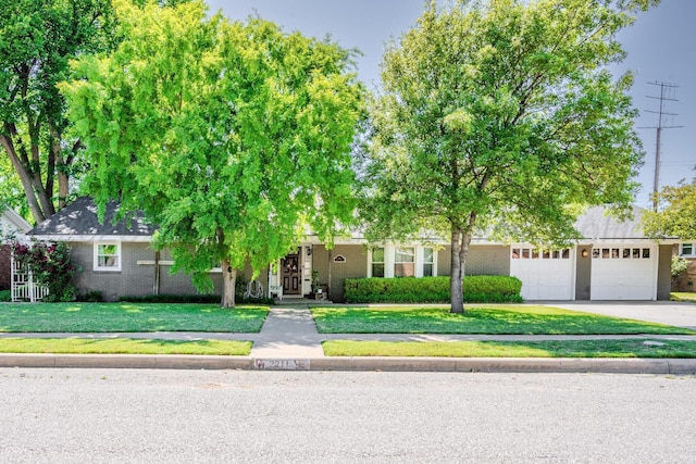 2211 N Aspen Dr, Pampa, TX 79065 - obstructed view of property with driveway, a front lawn, brick siding, and a garage