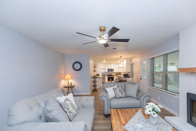 3301 Palmetto Trl, Amarillo, TX 79106 - living room with a fireplace, light wood finished floors, baseboards, a ceiling fan, and a textured ceiling