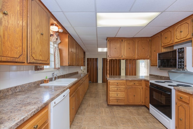2807 S Harrison St, Amarillo, TX 79109 - kitchen with white appliances, a sink, a drop ceiling, brown cabinetry, and a peninsula