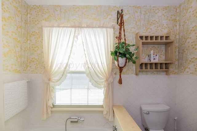 2807 S Harrison St, Amarillo, TX 79109 - full bathroom featuring a bathtub, wallpapered walls, toilet, and tile walls