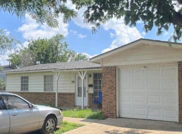 1627 Iris St, Amarillo, TX 79107 - ranch-style home with brick siding, a garage, and driveway