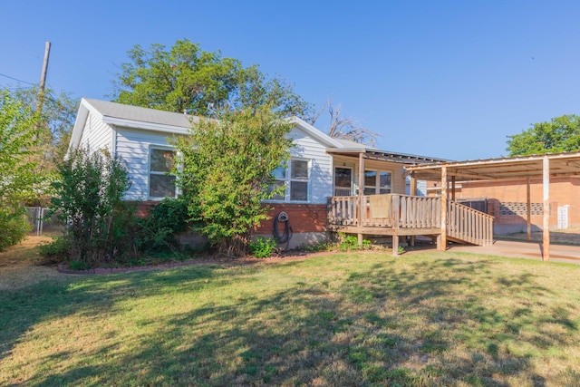 rear view of property featuring a deck and a yard